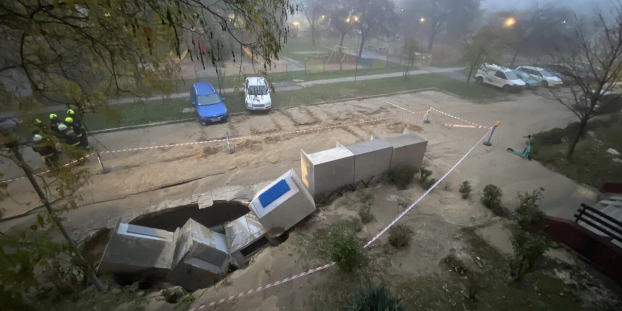 Most érkezett!  Durva csőtörés Csepelen, a kukatárolókkal együtt szakadt be az út – látványos helyszíni felvételek