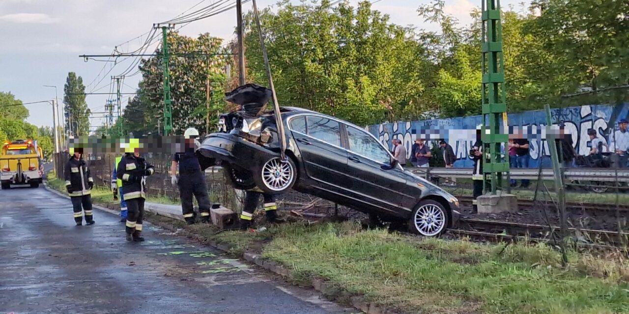 Tarolás a Szentendrei úton – a megcsúszó BMW kitörte a villanyoszlopot és a kerítést, majd a HÉV-síneken állt meg