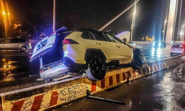 Látványos baleset az Erzsébet hídnál: a terelőelemek tetejére ugratott, majd fennakadt a Toyota HELYSZÍNI FOTÓKKAL!